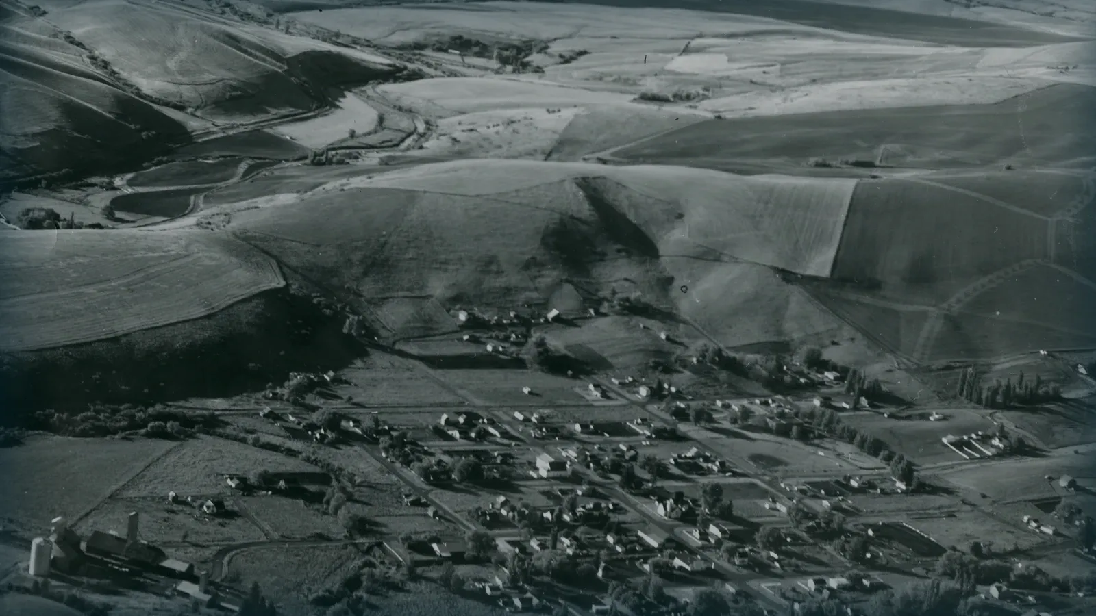 Fotografía aérea antigua de una población y sus campos.