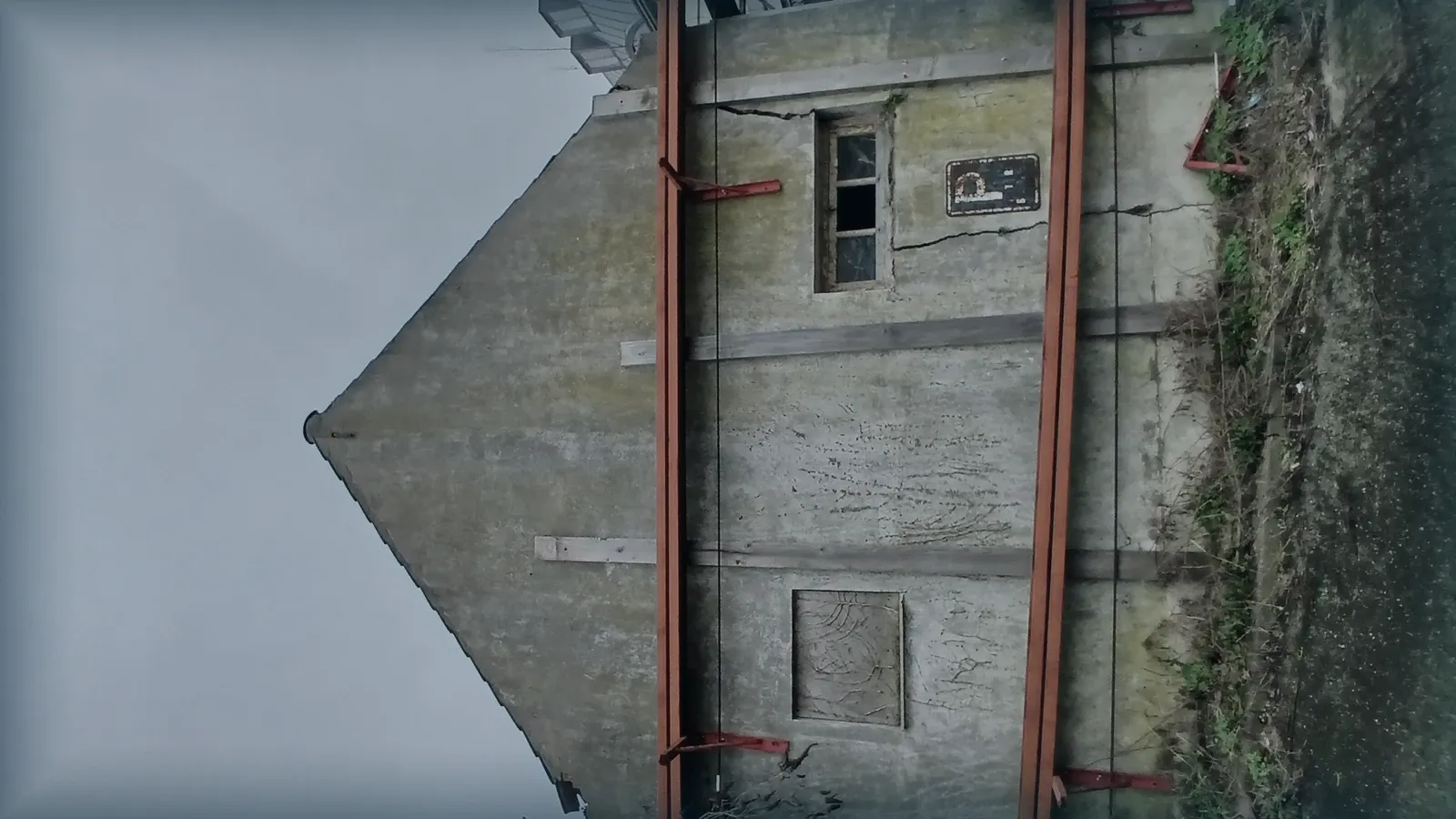 Medianera de un edificio con grietas estructurales y apuntalamiento.