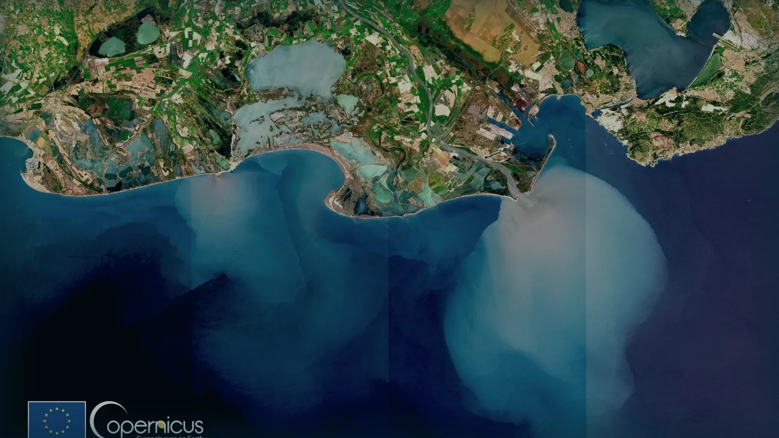 Pluma de sedimento de un río entrando en el mar, vista desde satélite.